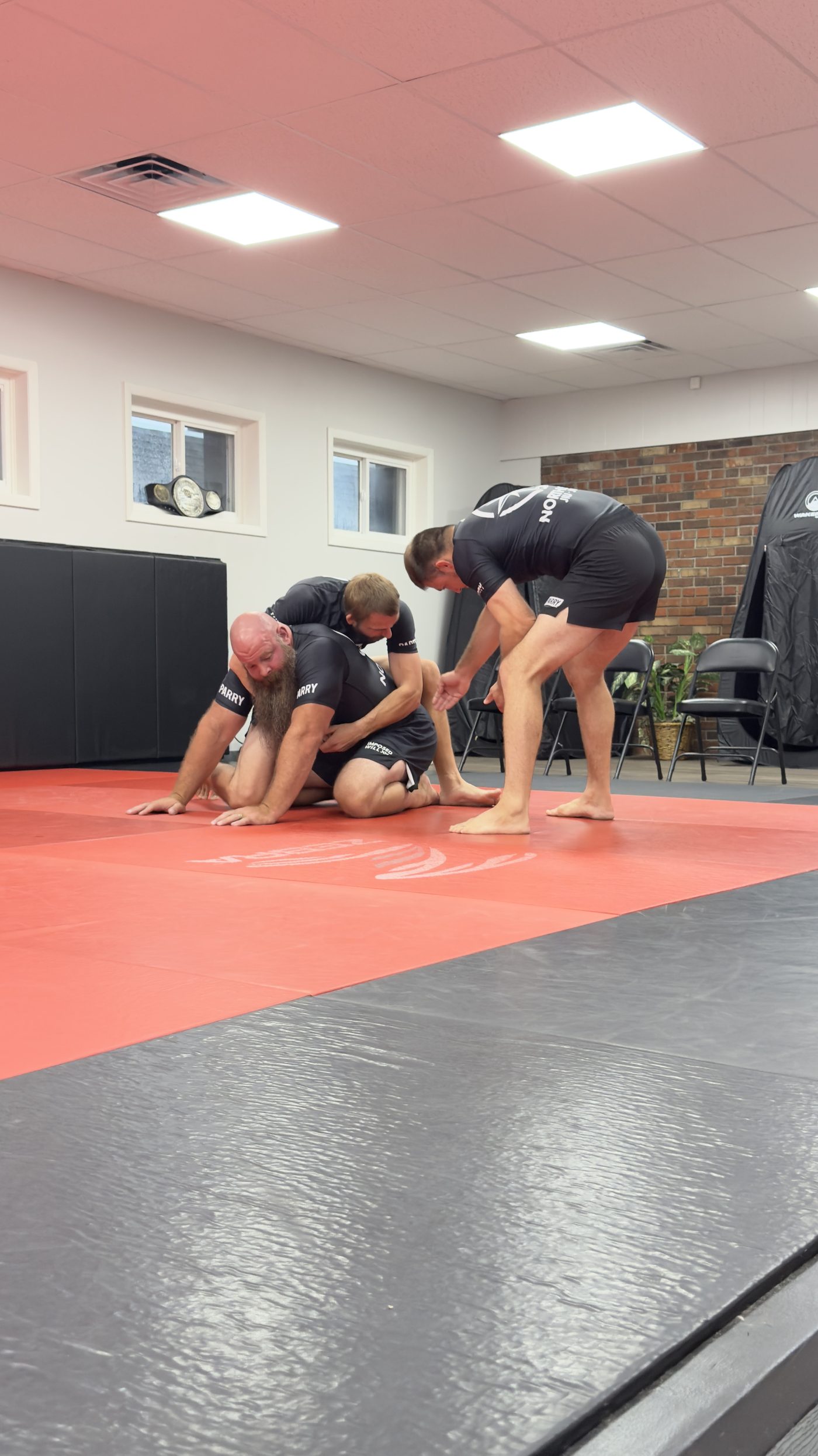Head instructor Nicholas Craton coaching adult students through a position during an All Levels class at Northstar Jiu Jitsu in Eau Claire