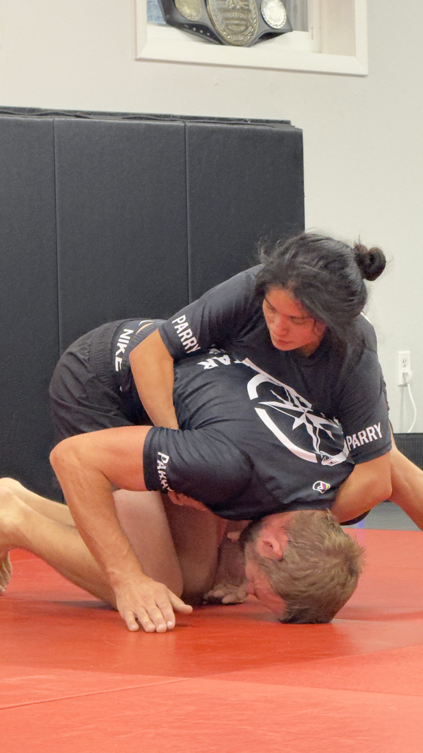 Coaches Martha and Nicholas Craton demonstrating a controlled top position on the mat at Northstar Jiu Jitsu in Eau Claire