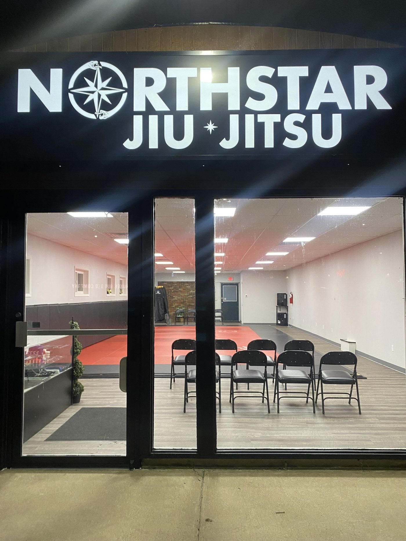 The lit Northstar Jiu Jitsu sign above the front doors at 2543 E Clairemont Ave in Eau Claire, Wisconsin